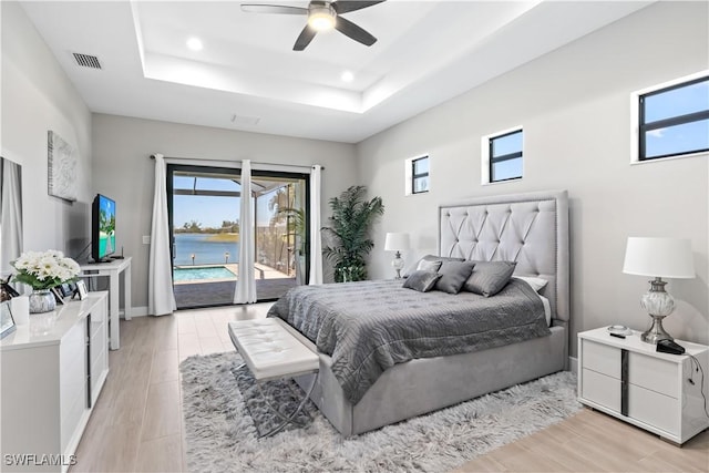 bedroom with visible vents, recessed lighting, access to exterior, a raised ceiling, and light wood-type flooring