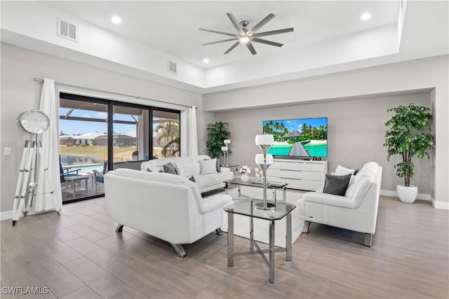 living room featuring visible vents, baseboards, and ceiling fan