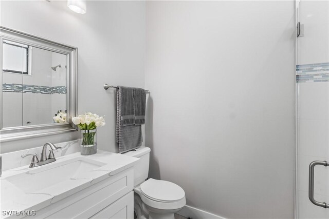 full bath featuring a shower with door, toilet, and vanity