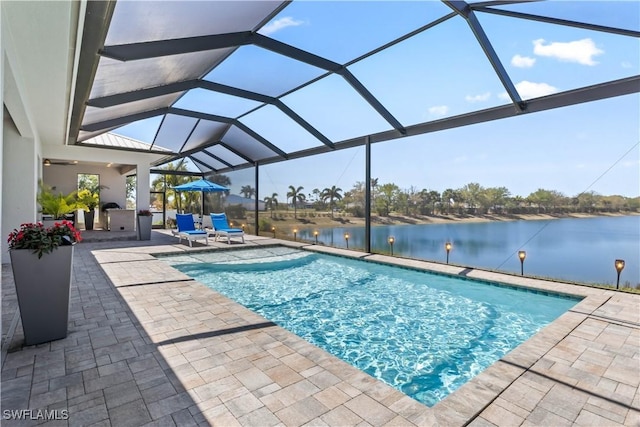 outdoor pool with a lanai, a patio area, and a water view