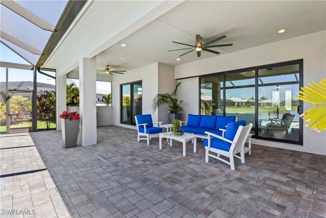 view of patio featuring an outdoor living space, glass enclosure, and a ceiling fan