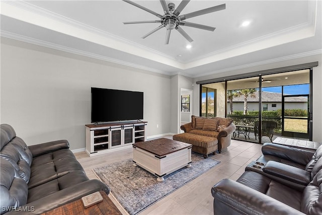 living room featuring ceiling fan, ornamental molding, and a tray ceiling