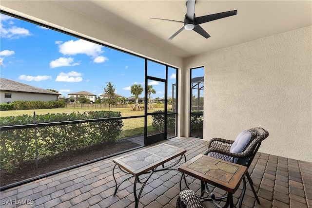 sunroom featuring ceiling fan