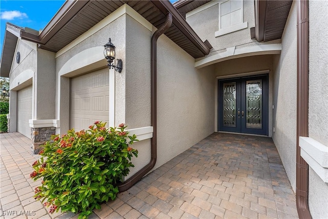 doorway to property with a garage and french doors