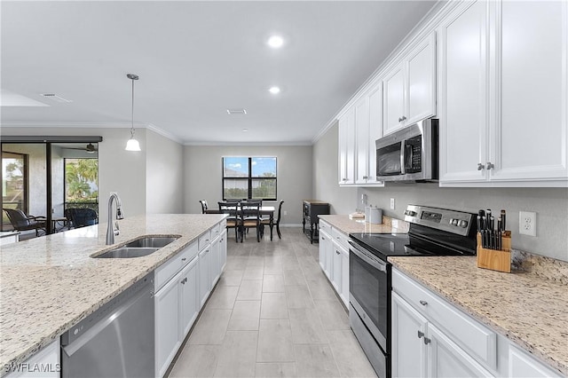 kitchen featuring appliances with stainless steel finishes, sink, light stone counters, white cabinetry, and decorative light fixtures