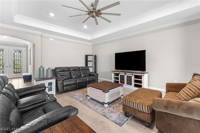 living room with french doors, crown molding, ceiling fan, and a raised ceiling