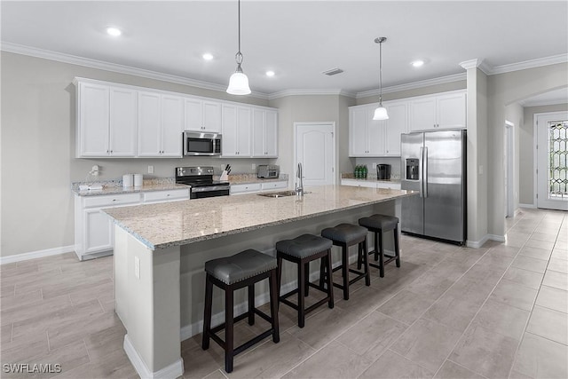 kitchen featuring appliances with stainless steel finishes, white cabinetry, and an island with sink