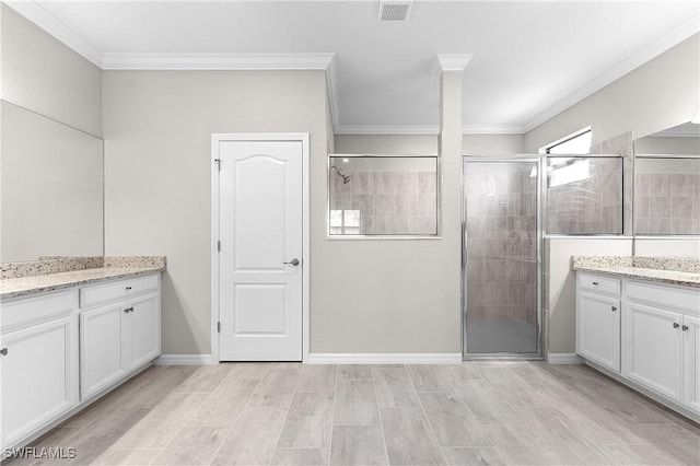 bathroom with crown molding, vanity, and walk in shower