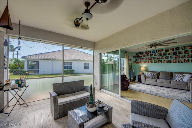 wooden deck with ceiling fan and outdoor lounge area