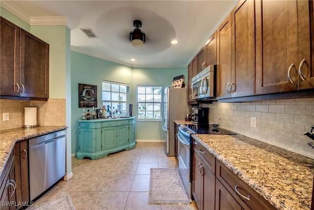 kitchen featuring crown molding, ceiling fan, appliances with stainless steel finishes, light stone countertops, and light tile patterned flooring