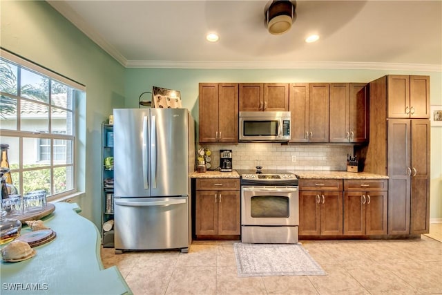 kitchen with light stone counters, stainless steel appliances, decorative backsplash, and plenty of natural light