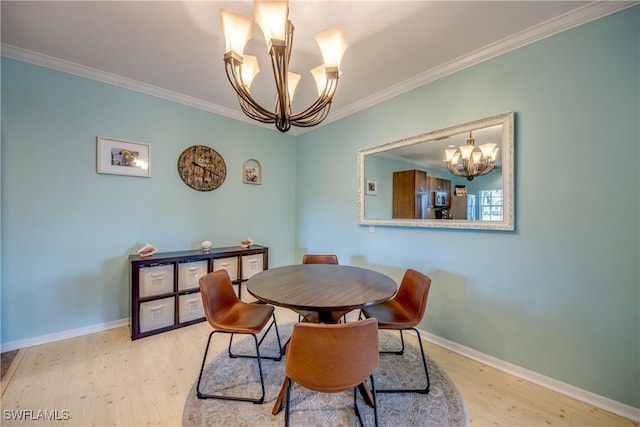 dining space with ornamental molding, light wood-type flooring, and a chandelier