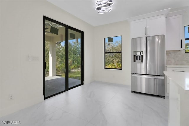 kitchen with white cabinetry, stainless steel fridge with ice dispenser, and backsplash