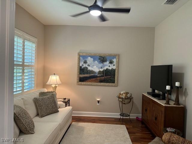 living room with ceiling fan and dark hardwood / wood-style floors