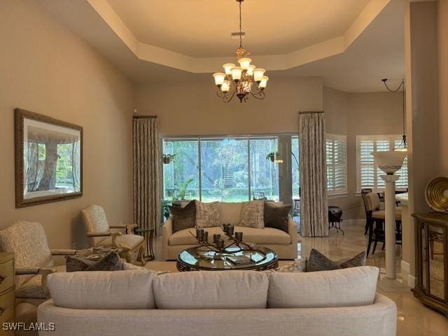 living room with a raised ceiling and a notable chandelier