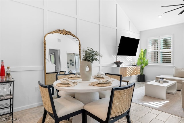 dining area with high vaulted ceiling, light hardwood / wood-style floors, and ceiling fan