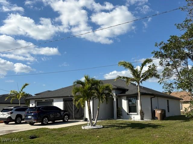 single story home with driveway, stucco siding, a garage, and a front yard