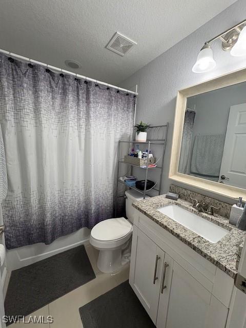 full bath featuring a textured ceiling, toilet, vanity, visible vents, and shower / bath combo