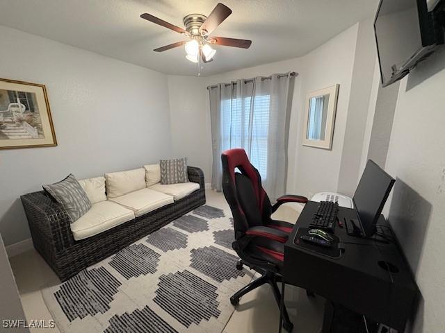 office area with ceiling fan and baseboards