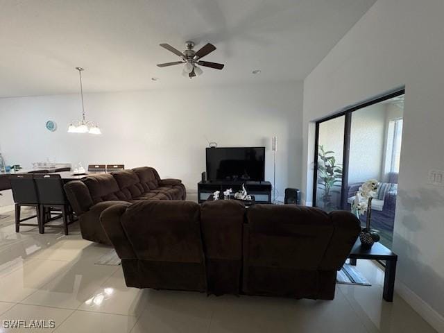 living room with light tile patterned floors and ceiling fan with notable chandelier