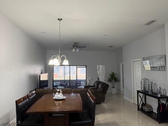 dining area with finished concrete floors, visible vents, baseboards, and ceiling fan with notable chandelier