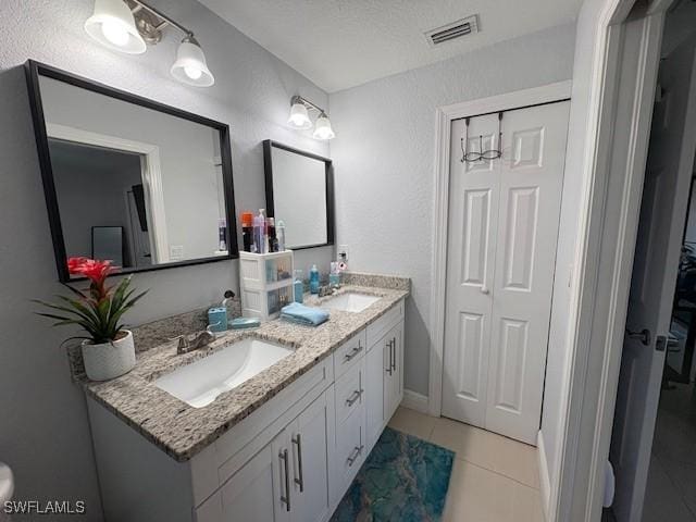 bathroom featuring double vanity, a closet, visible vents, and a sink