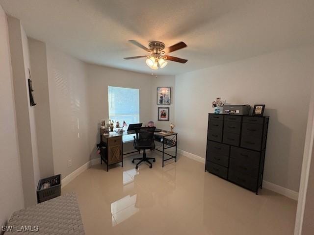 office area with ceiling fan and baseboards