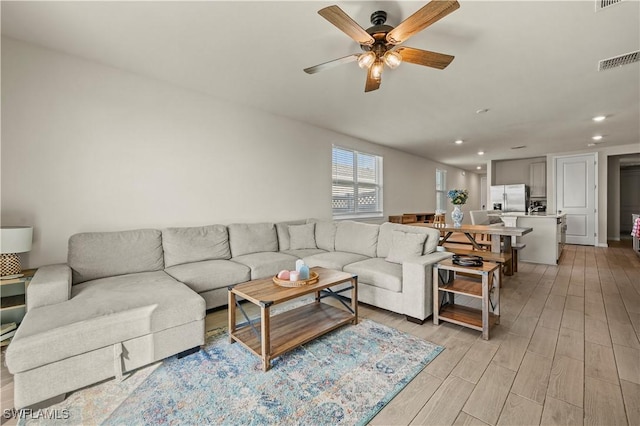 living room featuring ceiling fan and light hardwood / wood-style floors