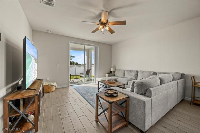 living room featuring wood-type flooring and ceiling fan