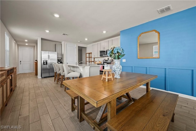 dining space with sink and light wood-type flooring