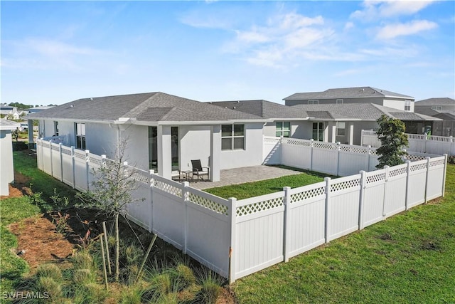 back of property with a patio area and a lawn