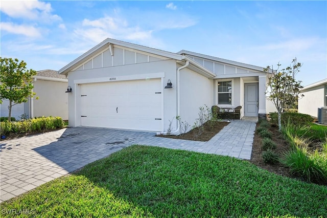 ranch-style house with a garage, a front yard, and central air condition unit