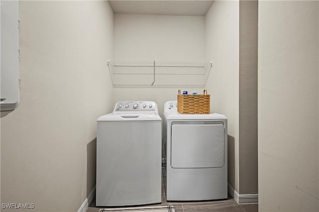 laundry room featuring washing machine and clothes dryer and dark hardwood / wood-style flooring