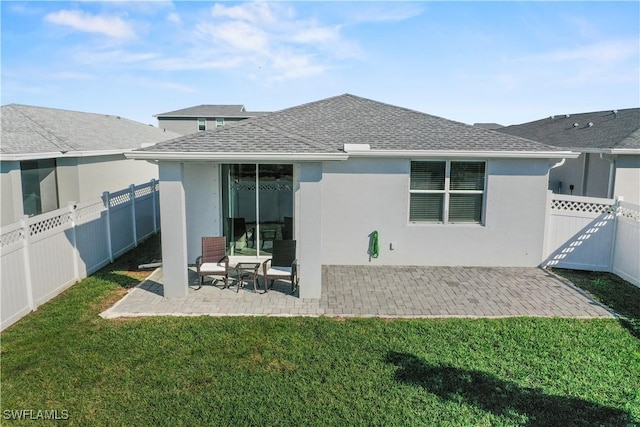 rear view of property featuring a yard and a patio