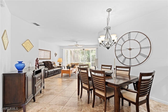 dining room with light tile patterned floors, ceiling fan with notable chandelier, visible vents, and baseboards