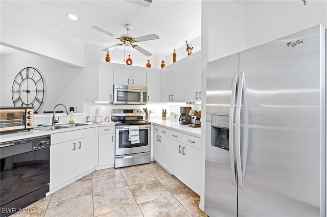 kitchen featuring light tile patterned floors, stainless steel appliances, light countertops, white cabinetry, and a sink