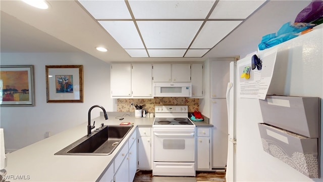 kitchen featuring white cabinets, sink, backsplash, and white appliances