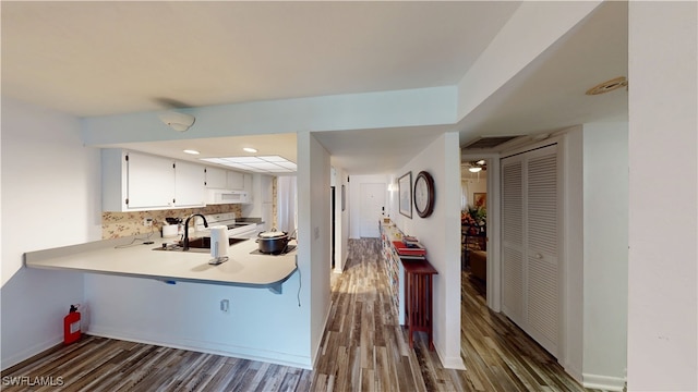 kitchen featuring tasteful backsplash, white cabinetry, sink, dark wood-type flooring, and white appliances