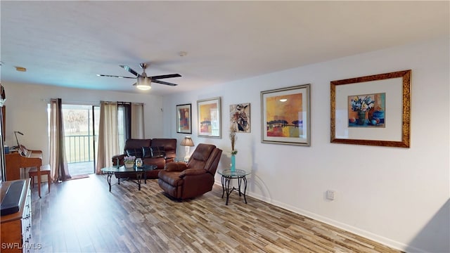 living room featuring light hardwood / wood-style flooring and ceiling fan