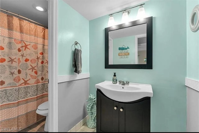 bathroom with walk in shower, vanity, toilet, and tile patterned flooring