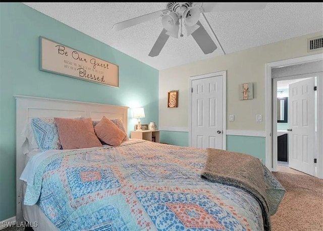 carpeted bedroom featuring ceiling fan and a textured ceiling