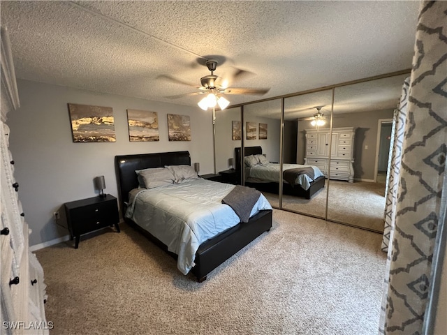 bedroom with ceiling fan, a closet, carpet flooring, and a textured ceiling