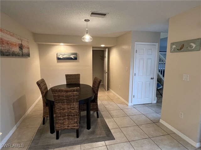 tiled dining space featuring a textured ceiling