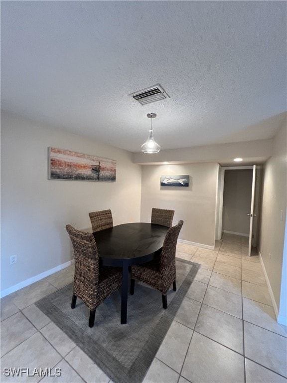 tiled dining room with a textured ceiling