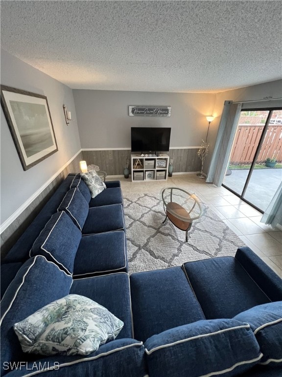 tiled living room featuring a textured ceiling and wooden walls