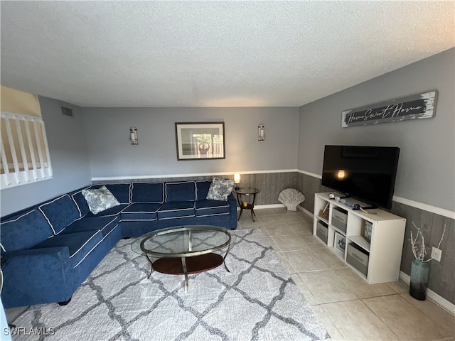 tiled living room featuring a textured ceiling