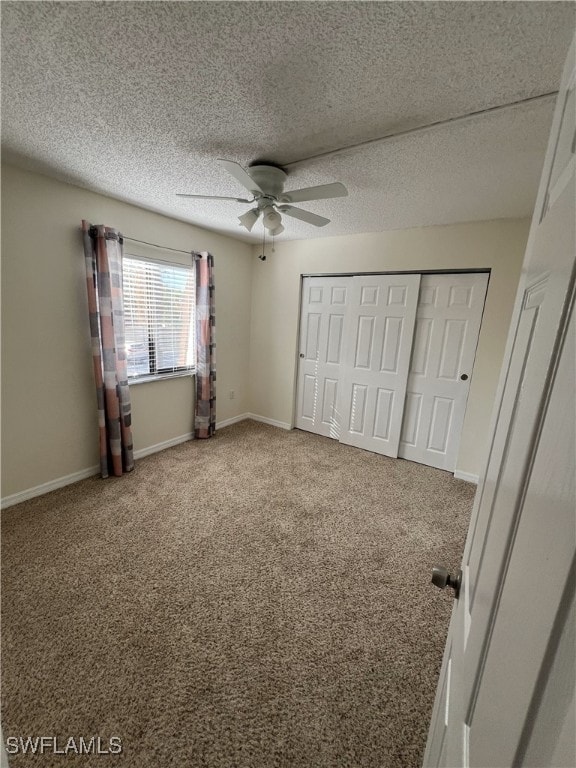 unfurnished bedroom with ceiling fan, carpet, a textured ceiling, and a closet