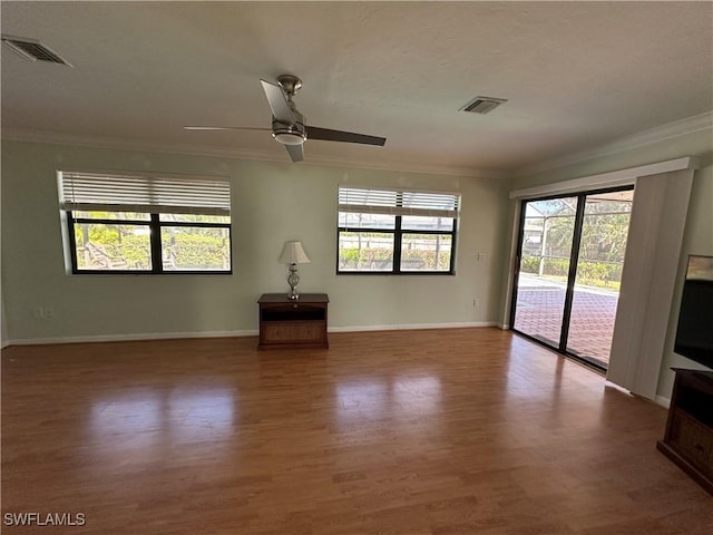 unfurnished living room with hardwood / wood-style flooring, ornamental molding, and ceiling fan