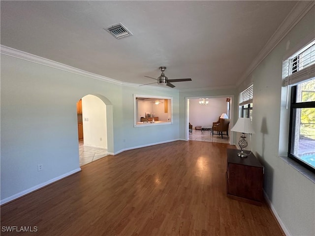 unfurnished living room featuring crown molding, ceiling fan with notable chandelier, and light hardwood / wood-style flooring