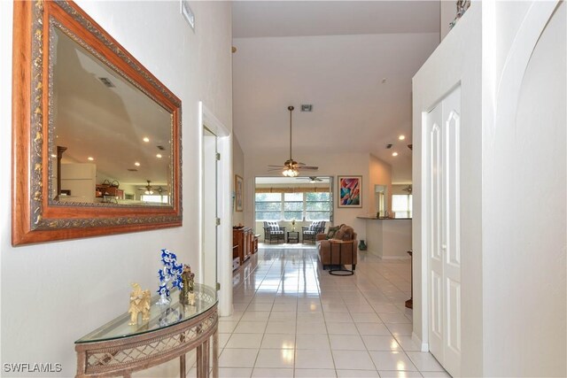 hallway with lofted ceiling and light tile patterned floors